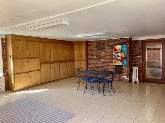 unfurnished dining area featuring brick wall and wooden walls