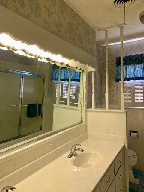 bathroom featuring vanity, walk in shower, a textured ceiling, and toilet