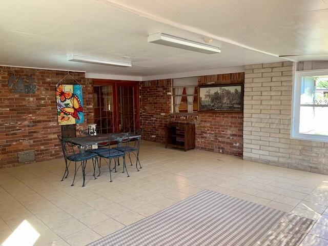 unfurnished dining area featuring brick wall