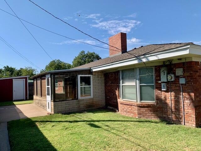 view of side of home with a yard