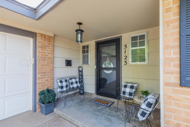 property entrance with brick siding and a porch