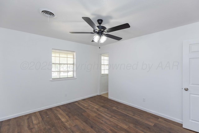 empty room with a ceiling fan, dark wood-style floors, and baseboards