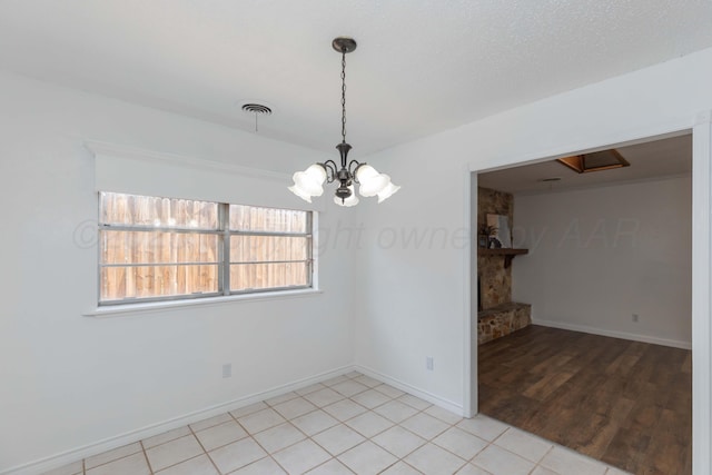 unfurnished room featuring a chandelier, baseboards, and light tile patterned floors