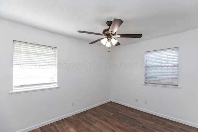 spare room with dark wood-style floors, ceiling fan, and baseboards