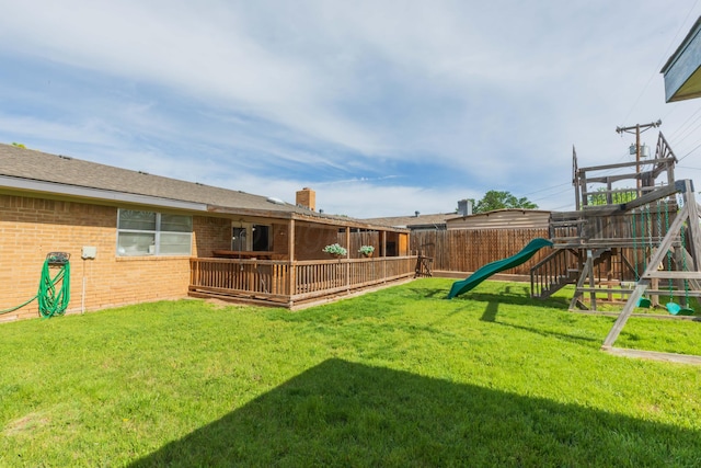 view of yard featuring a playground and a deck