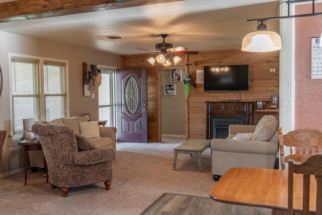 1002 S Main St, Wheeler, TX 79096 - living area with a ceiling fan, a fireplace, wood walls, and carpet flooring