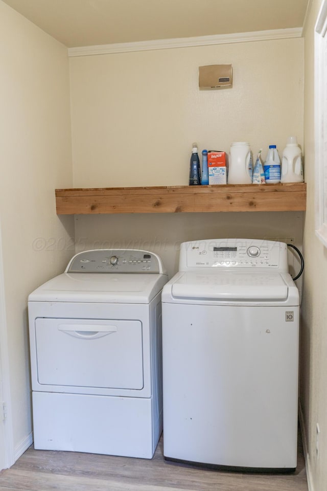 1002 S Main St, Wheeler, TX 79096 - laundry room featuring light wood-type flooring, washer and clothes dryer, and crown molding
