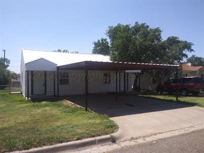 view of front facade featuring a carport and a front yard