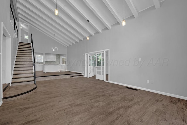 3700 Paramount Blvd, Amarillo, TX 79109 - unfurnished living room featuring high vaulted ceiling, beamed ceiling, wood finished floors, and stairway