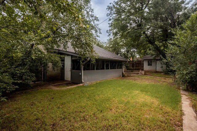 3700 Paramount Blvd, Amarillo, TX 79109 - view of grassy yard with a sunroom and a storage unit