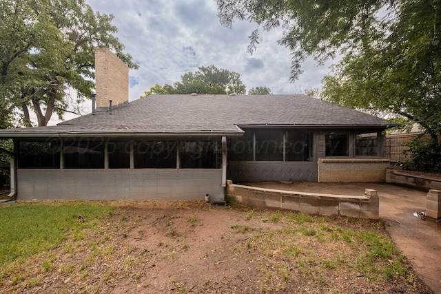 3700 Paramount Blvd, Amarillo, TX 79109 - rear view of property with a sunroom, a shingled roof, and a chimney