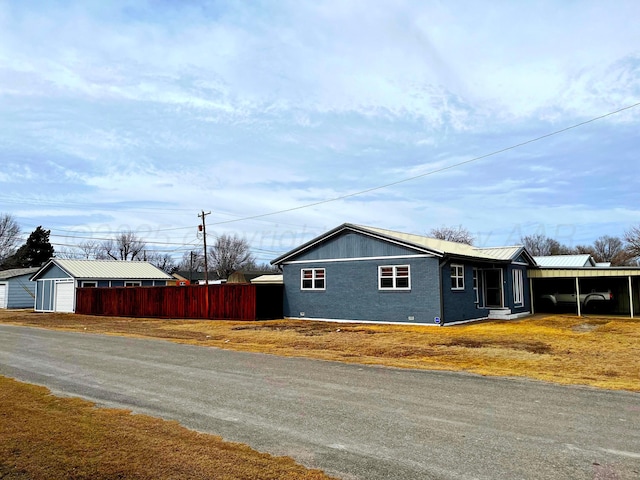 view of side of home featuring a garage, an outdoor structure, and a carport