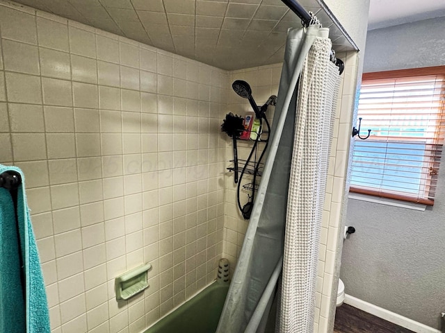 bathroom featuring shower / bath combo with shower curtain and toilet