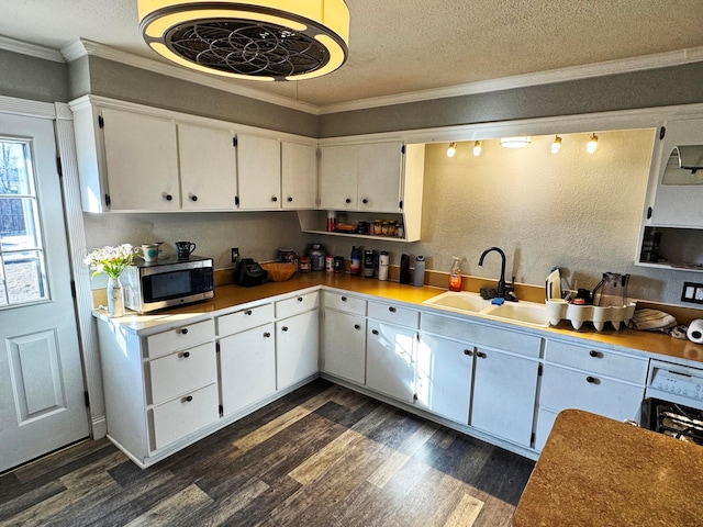 kitchen with sink, crown molding, white cabinetry, a textured ceiling, and dark hardwood / wood-style flooring