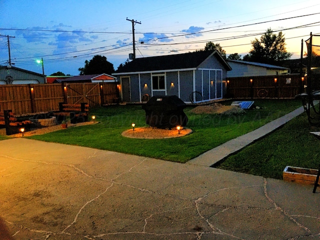 yard at dusk featuring an outbuilding