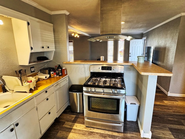 kitchen featuring dark wood-type flooring, stainless steel gas stove, crown molding, kitchen peninsula, and white cabinets