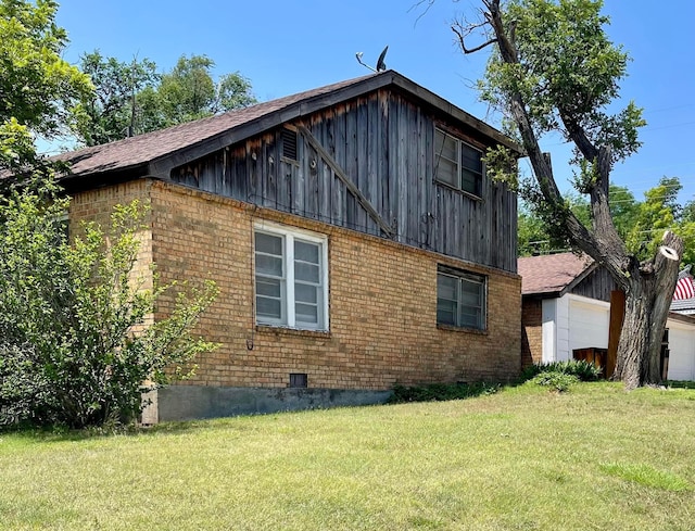 view of home's exterior featuring a lawn and an outdoor structure