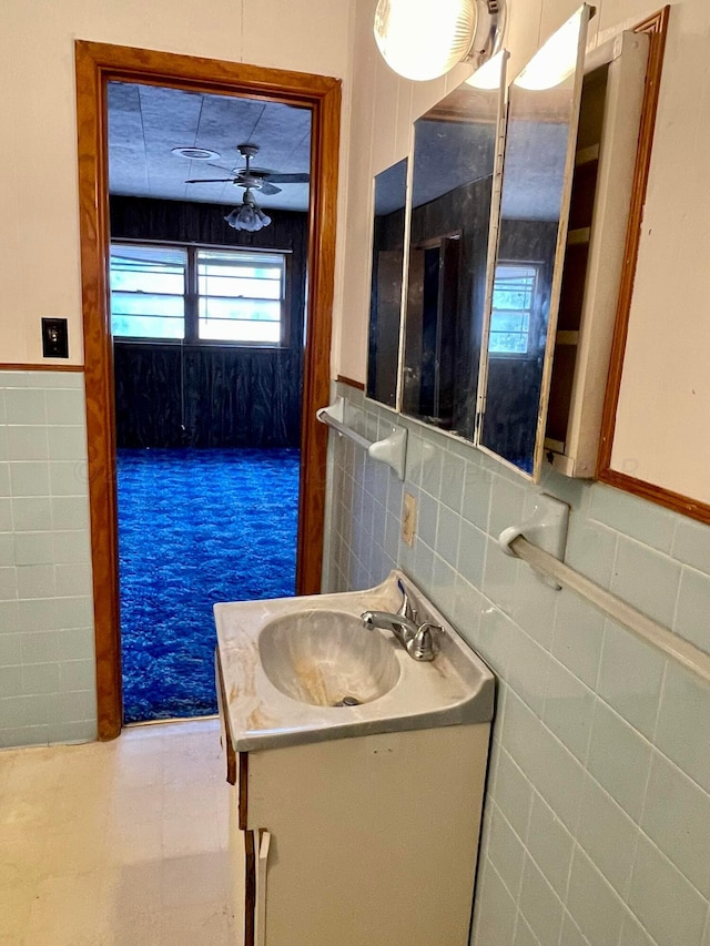 bathroom featuring vanity, ceiling fan, and tile walls