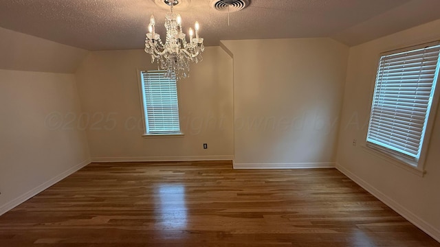 1011 S Lamar St, Amarillo, TX 79102 - spare room featuring lofted ceiling, a chandelier, wood finished floors, and a textured ceiling