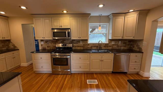 1011 S Lamar St, Amarillo, TX 79102 - kitchen with appliances with stainless steel finishes, light wood-type flooring, tasteful backsplash, decorative light fixtures, and recessed lighting