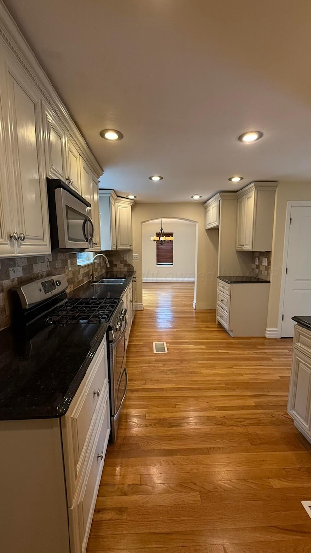 1011 S Lamar St, Amarillo, TX 79102 - kitchen featuring stainless steel appliances, light wood finished floors, recessed lighting, and backsplash