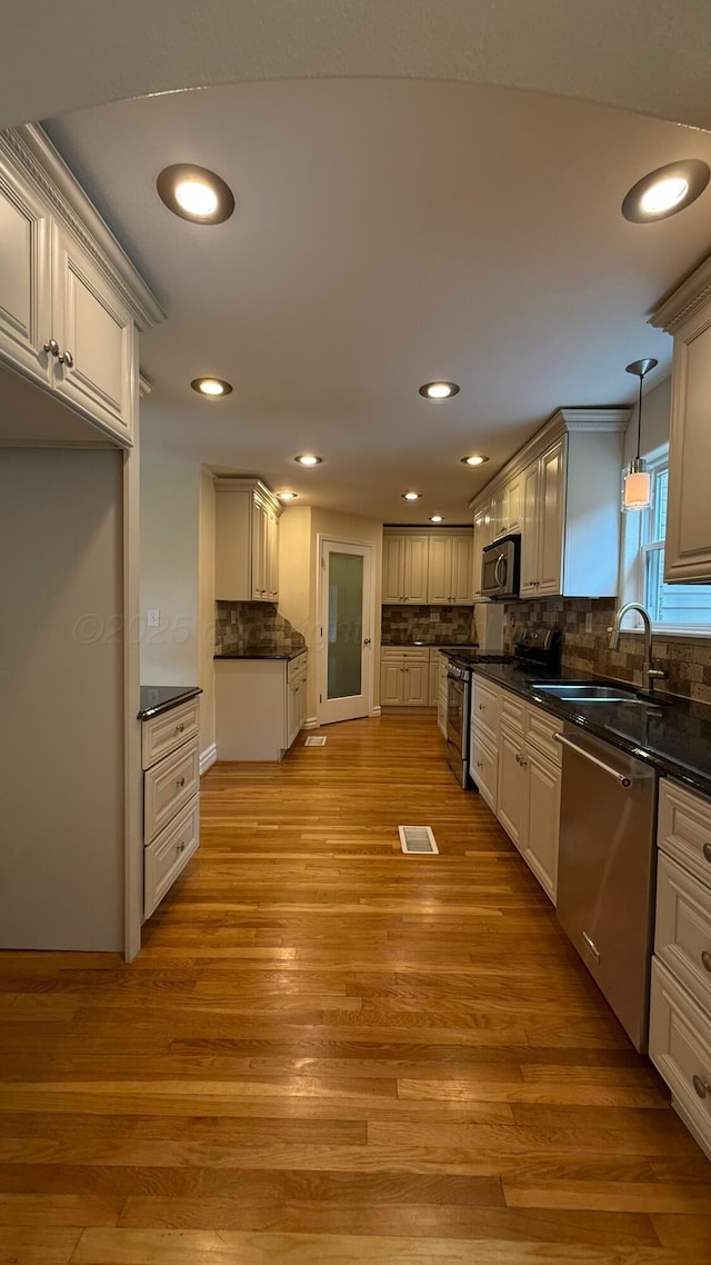 1011 S Lamar St, Amarillo, TX 79102 - kitchen featuring appliances with stainless steel finishes, dark countertops, recessed lighting, light wood-type flooring, and backsplash