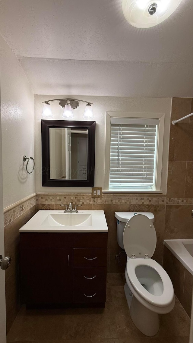1011 S Lamar St, Amarillo, TX 79102 - bathroom with tile walls, vanity, and tiled shower / bath combo