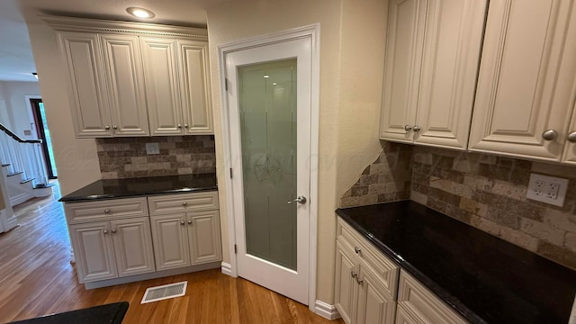 1011 S Lamar St, Amarillo, TX 79102 - kitchen with dark countertops, light wood-style flooring, and tasteful backsplash