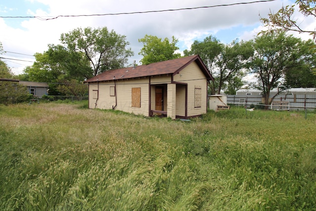 view of outbuilding featuring fence and an outdoor structure