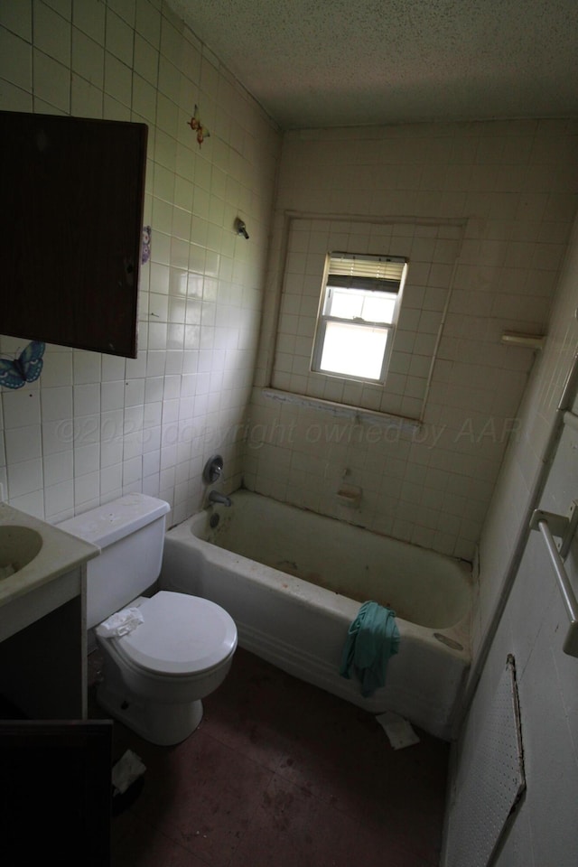 bathroom featuring toilet, a textured ceiling, vanity, tile walls, and tile patterned floors