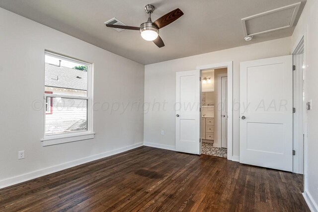 unfurnished bedroom with dark wood-type flooring, ceiling fan, and connected bathroom