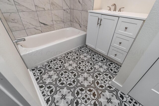 bathroom featuring tile patterned flooring, a bath, and vanity