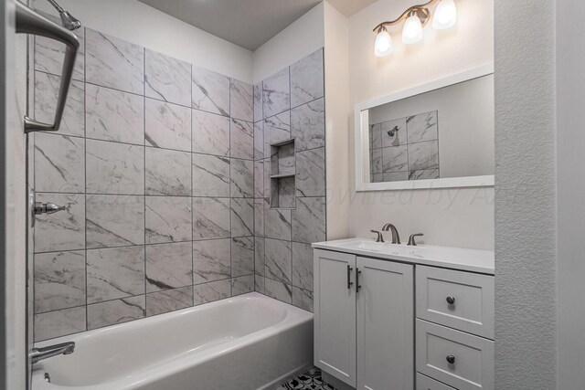 bathroom featuring tiled shower / bath and vanity