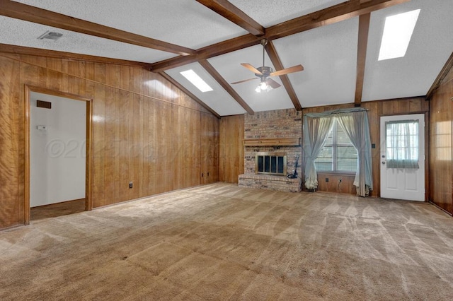 105 Pinehurst St, Borger, TX 79007 - unfurnished living room featuring wooden walls, a ceiling fan, a fireplace, light carpet, and a textured ceiling