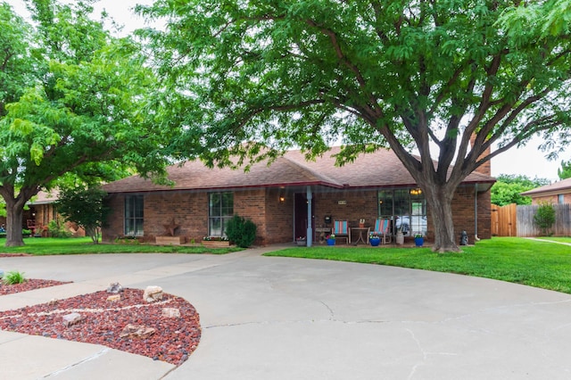 7919 Mitcham Dr, Amarillo, TX 79121 - ranch-style home featuring brick siding, a shingled roof, and curved driveway