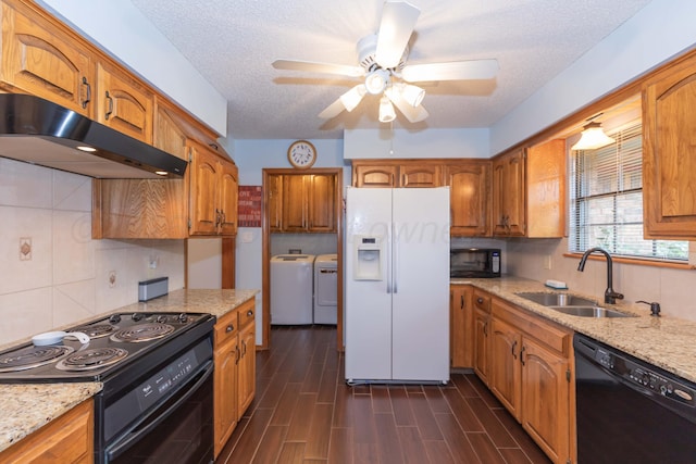 7919 Mitcham Dr, Amarillo, TX 79121 - kitchen featuring black appliances, under cabinet range hood, washing machine and dryer, brown cabinets, and a ceiling fan