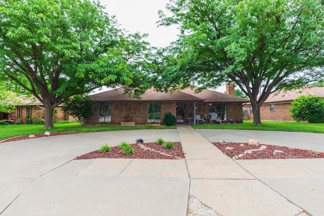 7919 Mitcham Dr, Amarillo, TX 79121 - ranch-style home with a chimney, a front lawn, curved driveway, and roof with shingles