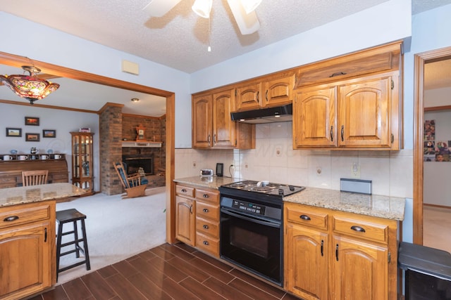 7919 Mitcham Dr, Amarillo, TX 79121 - kitchen with black range with electric stovetop, under cabinet range hood, ceiling fan, light stone countertops, and a brick fireplace