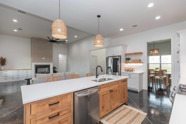 kitchen featuring stainless steel appliances, sink, a center island with sink, and white cabinets