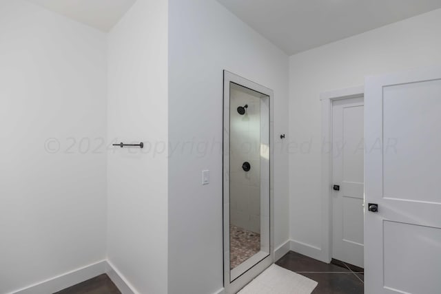 bathroom with tile patterned floors and tiled shower