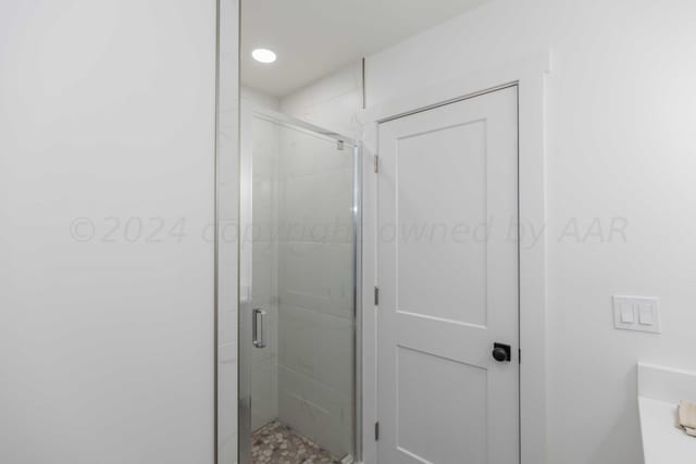 bathroom featuring a shower with door