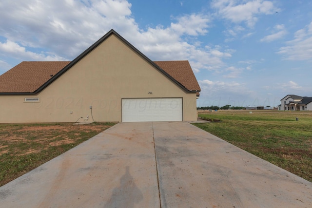 view of side of home with a lawn and a garage
