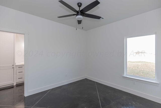 tiled empty room featuring ceiling fan