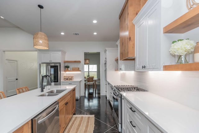 kitchen featuring white cabinetry, sink, appliances with stainless steel finishes, tasteful backsplash, and hanging light fixtures