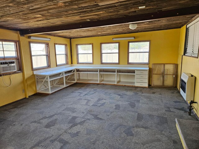 interior space with beamed ceiling, heating unit, and a healthy amount of sunlight