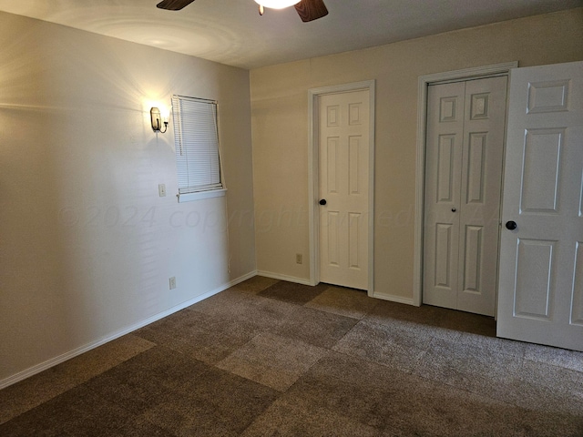 unfurnished bedroom featuring ceiling fan, multiple closets, and carpet floors