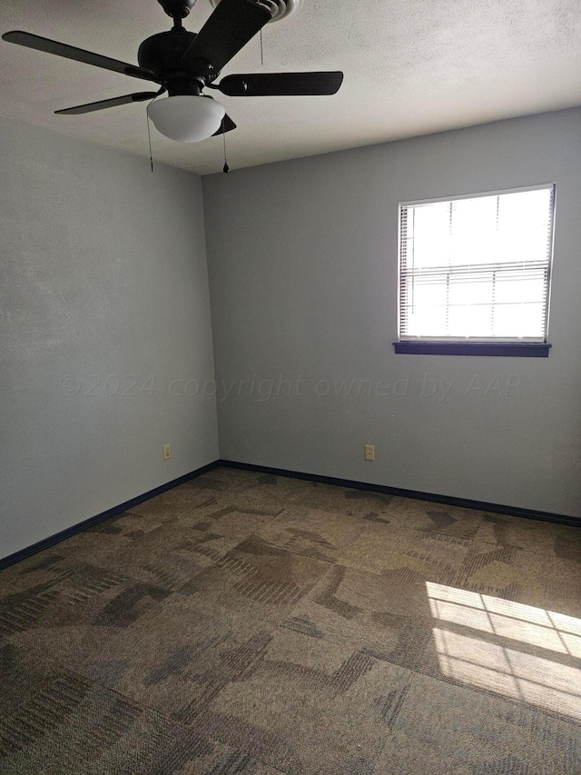 carpeted spare room with ceiling fan and a textured ceiling