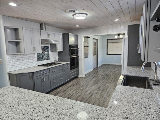 kitchen featuring white fridge, gray cabinets, dark hardwood / wood-style flooring, sink, and stainless steel gas stovetop