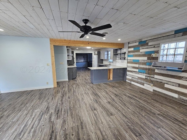 kitchen featuring kitchen peninsula, a kitchen breakfast bar, ceiling fan, backsplash, and dark hardwood / wood-style flooring