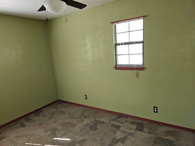 carpeted spare room featuring ceiling fan